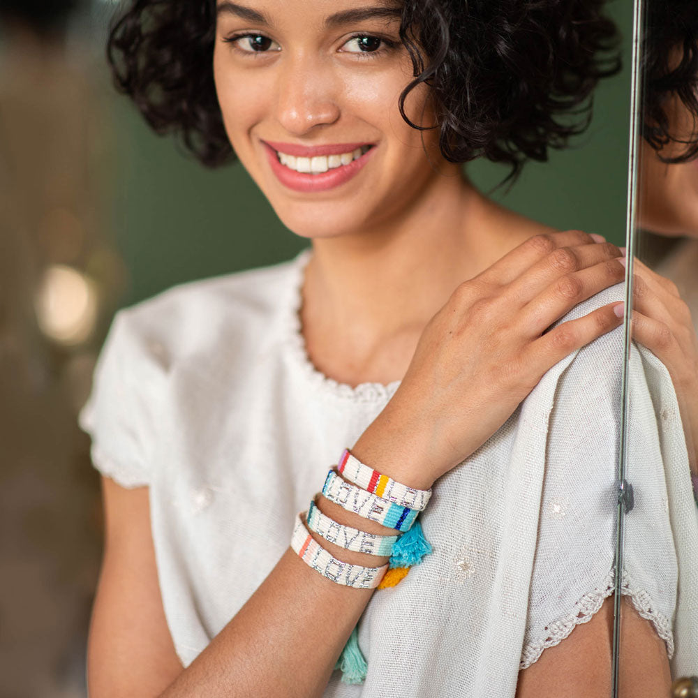 A model wearing the White, Peach, and Orange Atitlan LOVE Bracelet from Love is Project