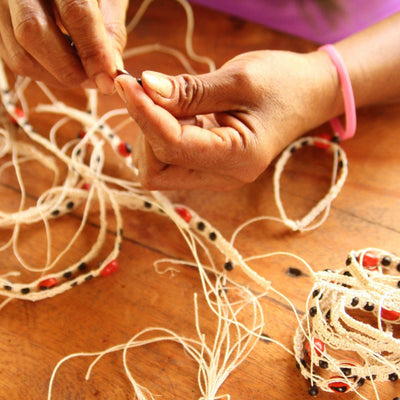 An artisan makes the Amazon Enamora Bracelets - Love Is Project
