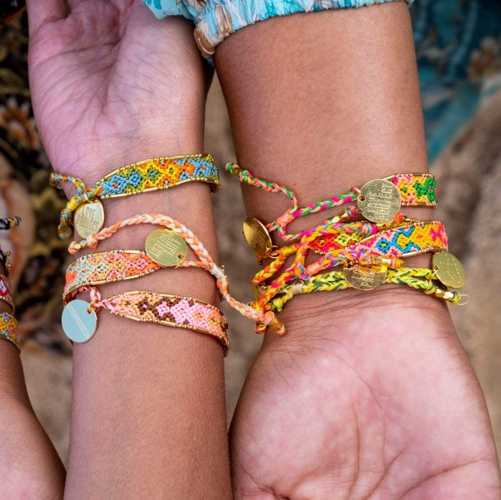 Models wearing stacks of the Jungle Bloom Bali Friendship Bracelets from Love Is Project