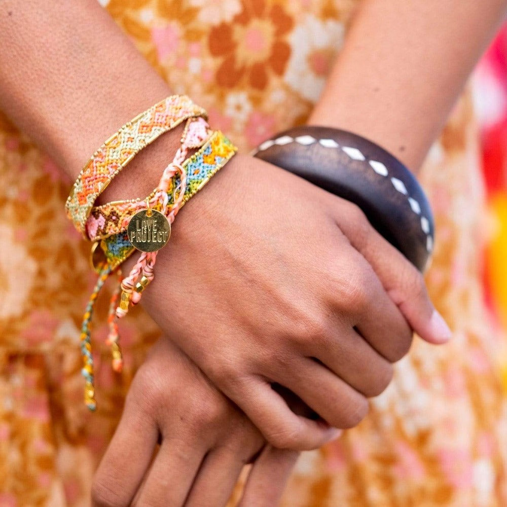 A model wearing the Aloha Bali Friendship Bracelet Stack from Love Is Project