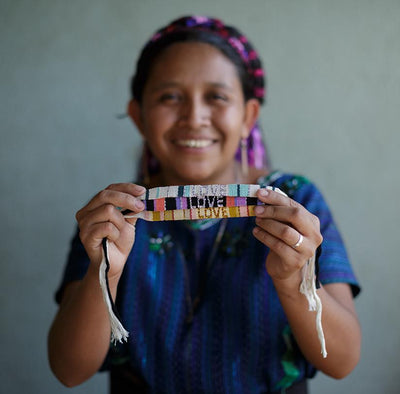 An artisan holds the Atitlan LOVE Bracelets from Love Is Project