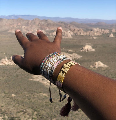 A model wearing the Desert Opal Bali Friendship Bracelet from Love Is Project over mountains